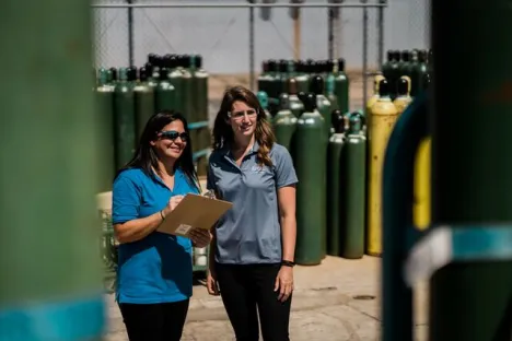 Frauen überprüfen draußen Gasflaschenbestand